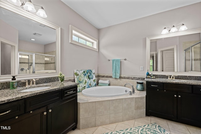 12216 Kyle Abbey Ln, Raleigh, NC 27613 - full bath featuring tile patterned flooring, a shower stall, two vanities, and a bath