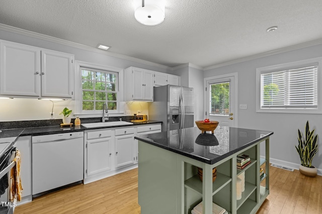 15 Gray Fox Ct, Durham, NC 27713 - kitchen with appliances with stainless steel finishes, a sink, open shelves, light wood-type flooring, and a textured ceiling