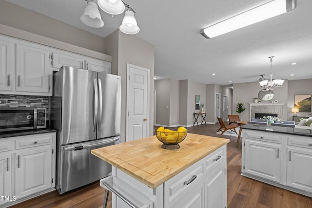 107 Covington Dr, Chapel Hill, NC 27514 - kitchen featuring stainless steel appliances, a fireplace, white cabinetry, and decorative backsplash