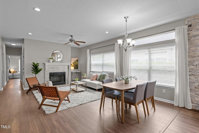 107 Covington Dr, Chapel Hill, NC 27514 - dining space featuring a textured ceiling, wood finished floors, a fireplace, ceiling fan, and baseboards