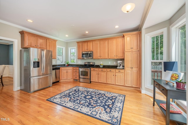 1230 Golden Bluff Ln, Fuquay Varina, NC 27526 - kitchen featuring appliances with stainless steel finishes, dark countertops, plenty of natural light, light wood-style floors, and crown molding