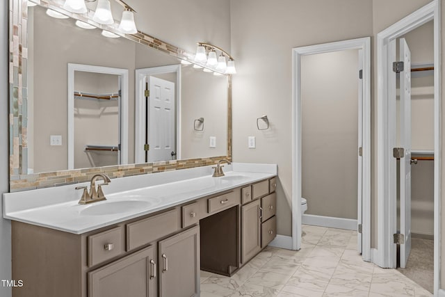 3306 Meadowrun Dr, Durham, NC 27707 - bathroom featuring double vanity, a spacious closet, and marble look tiles