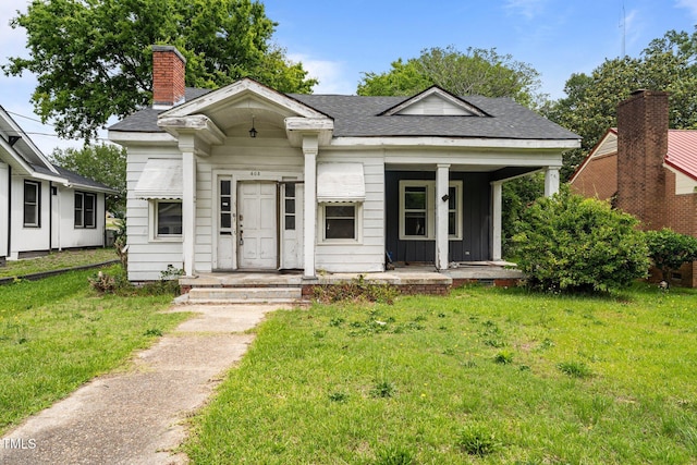 403 E Mulberry St, Goldsboro, NC 27530 - view of front of house featuring a front yard, a shingled roof, a chimney, and covered porch
