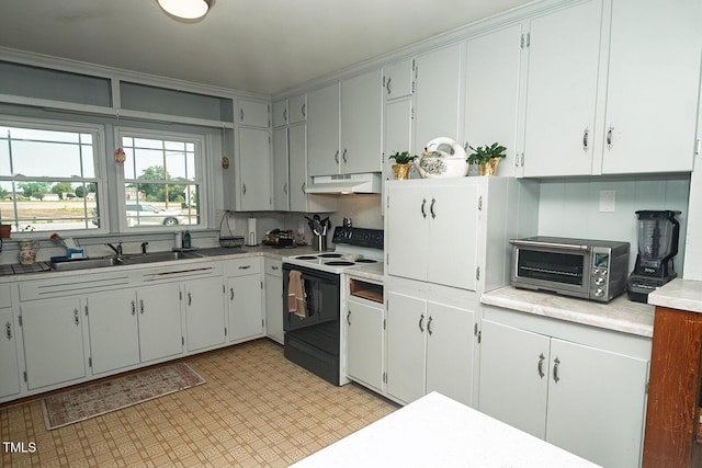 336 Goldsboro St, Newton Grove, NC 28366 - kitchen featuring electric range, under cabinet range hood, a sink, light flooring, and light countertops