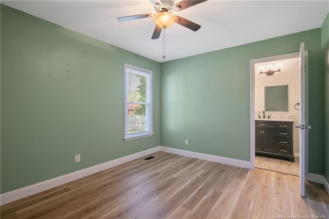 2298 Hackney Loop, Fayetteville, NC 28304 - unfurnished bedroom with light wood-type flooring, baseboards, ensuite bathroom, and a sink