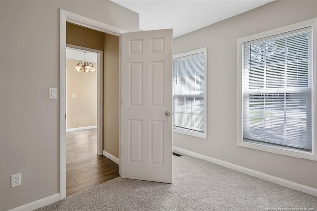 2298 Hackney Loop, Fayetteville, NC 28304 - carpeted spare room featuring baseboards and a chandelier