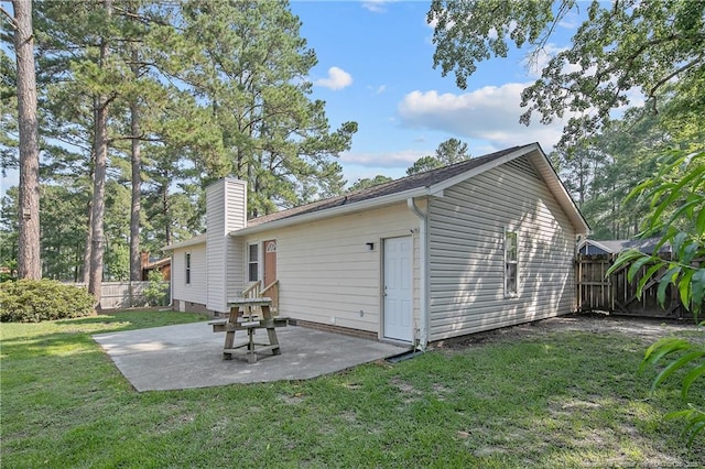 2298 Hackney Loop, Fayetteville, NC 28304 - rear view of property featuring a chimney and a patio