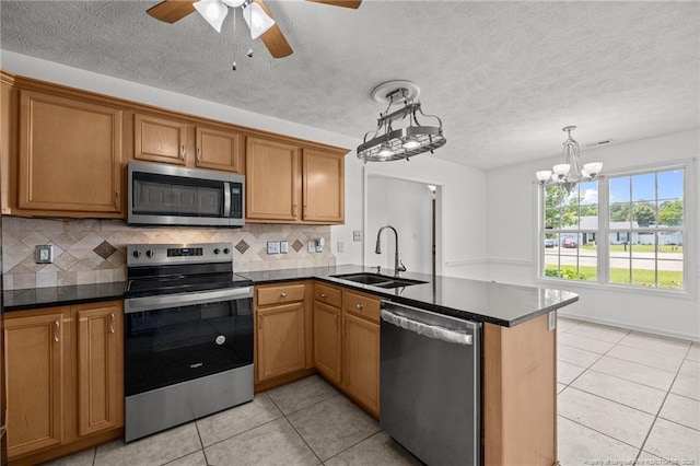 107 Hayes Ct, Raeford, NC 28376 - kitchen featuring appliances with stainless steel finishes, a sink, a peninsula, light tile patterned flooring, and a textured ceiling