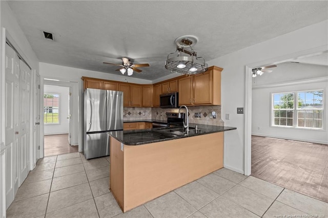107 Hayes Ct, Raeford, NC 28376 - kitchen featuring stainless steel appliances, a ceiling fan, a peninsula, light tile patterned floors, and plenty of natural light