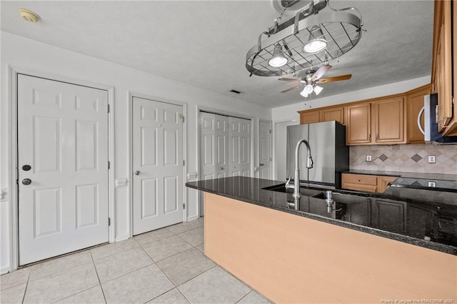 107 Hayes Ct, Raeford, NC 28376 - kitchen with stainless steel appliances, a peninsula, dark stone countertops, brown cabinets, and ceiling fan