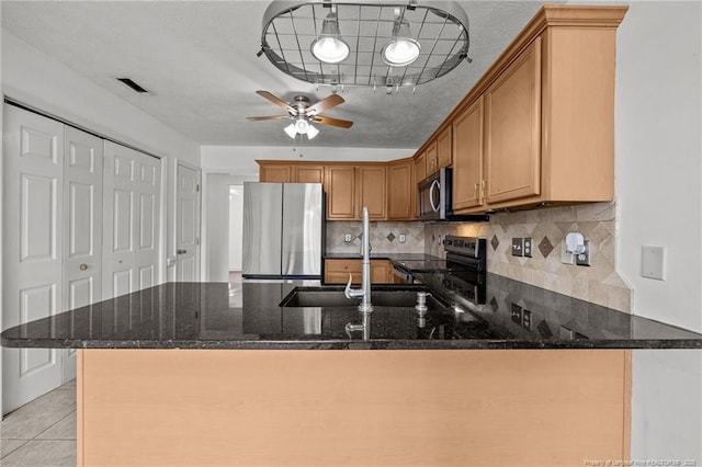 107 Hayes Ct, Raeford, NC 28376 - kitchen with appliances with stainless steel finishes, a peninsula, dark stone countertops, a sink, and a ceiling fan