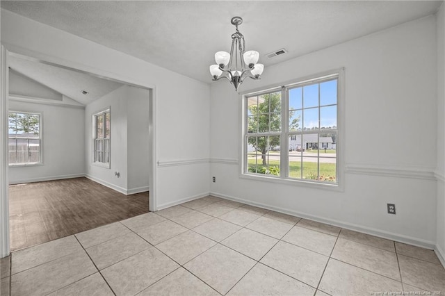 107 Hayes Ct, Raeford, NC 28376 - spare room featuring a chandelier, plenty of natural light, tile patterned flooring, baseboards, and vaulted ceiling