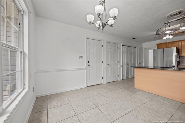107 Hayes Ct, Raeford, NC 28376 - kitchen featuring freestanding refrigerator, a chandelier, light tile patterned floors, baseboards, and brown cabinets
