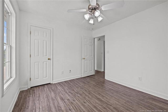 107 Hayes Ct, Raeford, NC 28376 - unfurnished bedroom featuring dark wood-style floors, multiple windows, and baseboards