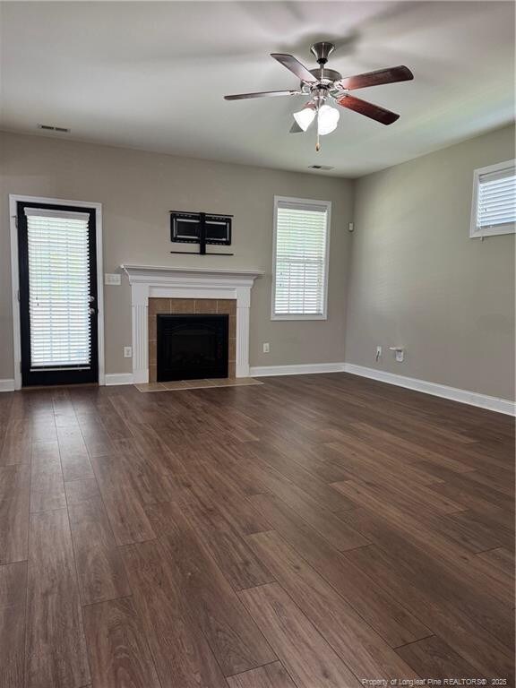 1545 Gallant Fox Ct, Parkton, NC 28371 - unfurnished living room with a fireplace, dark wood-style flooring, ceiling fan, and healthy amount of natural light