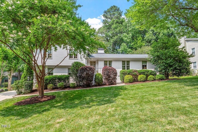 3308 Cobblestone Ct, Raleigh, NC 27607 - split level home with brick siding, a front lawn, and a chimney