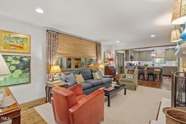 3308 Cobblestone Ct, Raleigh, NC 27607 - living area with wood finished floors, crown molding, recessed lighting, and baseboards