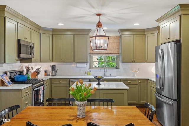 3308 Cobblestone Ct, Raleigh, NC 27607 - kitchen with stainless steel appliances, a sink, light countertops, pendant lighting, and decorative backsplash