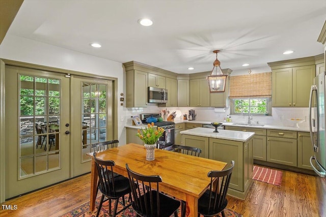 3308 Cobblestone Ct, Raleigh, NC 27607 - kitchen with stainless steel appliances, a sink, light countertops, dark wood-style floors, and tasteful backsplash