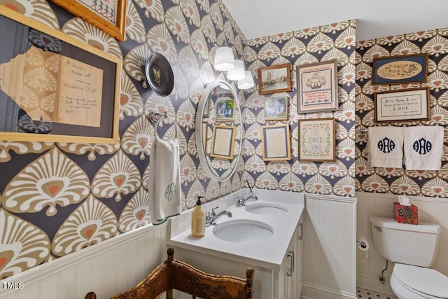 3308 Cobblestone Ct, Raleigh, NC 27607 - bathroom featuring wallpapered walls, toilet, a wainscoted wall, and double vanity