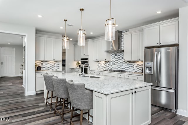 2516 Del Webb Gardens Dr, Fuquay Varina, NC 27526 - kitchen featuring appliances with stainless steel finishes, a sink, dark wood finished floors, decorative backsplash, and an island with sink