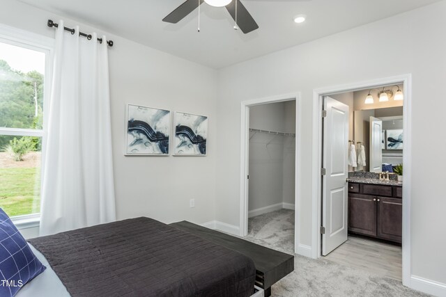 2516 Del Webb Gardens Dr, Fuquay Varina, NC 27526 - bedroom with light carpet, multiple windows, a spacious closet, and baseboards