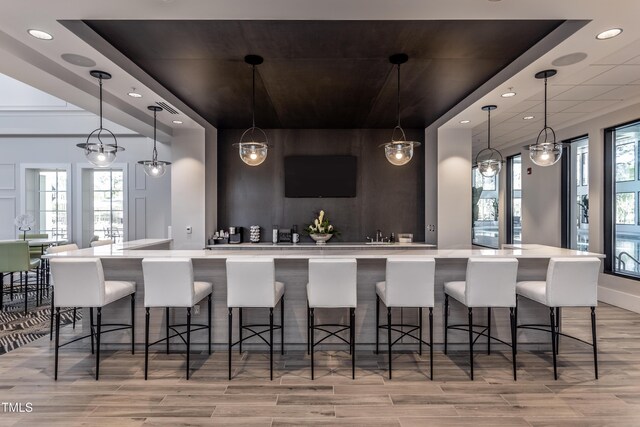 2516 Del Webb Gardens Dr, Fuquay Varina, NC 27526 - kitchen featuring light countertops, light wood-style flooring, recessed lighting, a breakfast bar, and decorative light fixtures