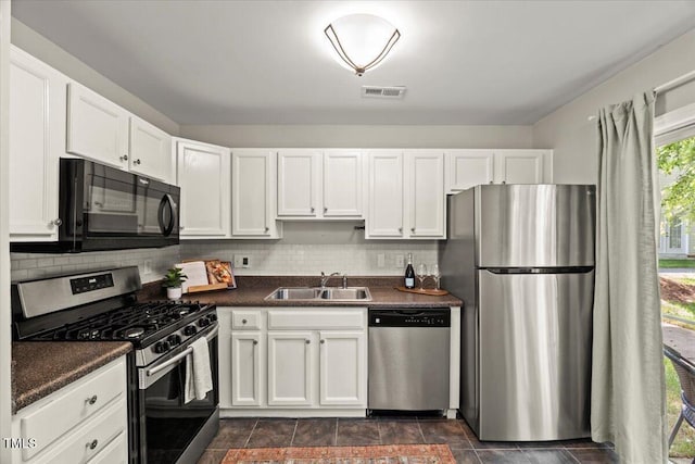2920 Barrymore St Unit 106, Raleigh, NC 27603 - kitchen with appliances with stainless steel finishes, dark countertops, white cabinets, and backsplash