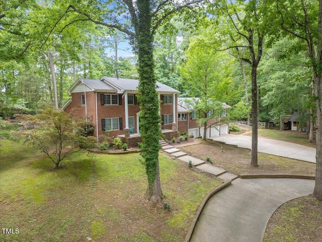 9801 Honeycutt Rd, Raleigh, NC 27614 - neoclassical home with concrete driveway, brick siding, and a front lawn