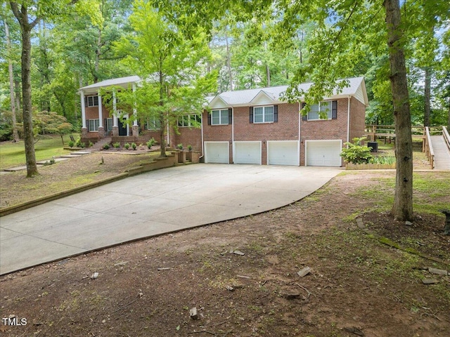 9801 Honeycutt Rd, Raleigh, NC 27614 - view of front of home featuring concrete driveway, a garage, brick siding, and view of scattered trees