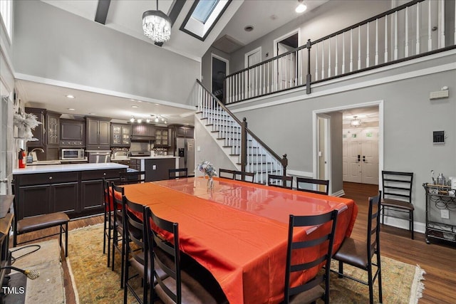 9801 Honeycutt Rd, Raleigh, NC 27614 - dining area featuring a high ceiling, wood finished floors, a chandelier, and stairway