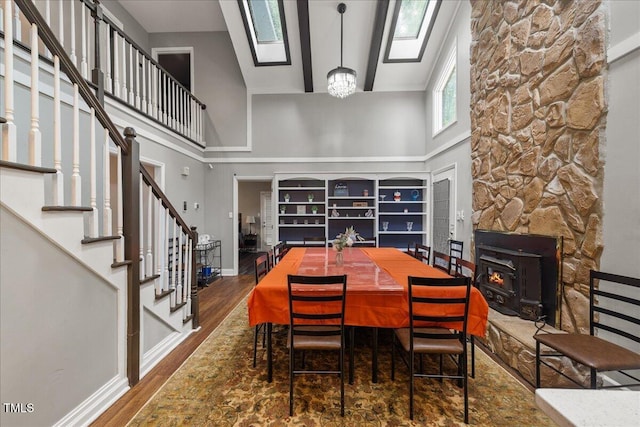 9801 Honeycutt Rd, Raleigh, NC 27614 - dining space with a high ceiling, wood finished floors, baseboards, a wood stove, and stairs