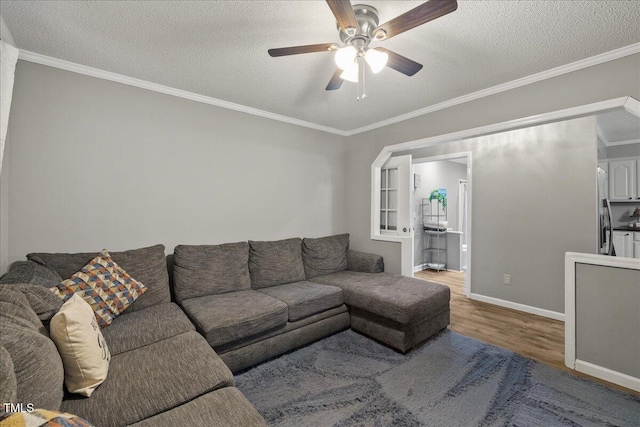 9801 Honeycutt Rd, Raleigh, NC 27614 - living room with wood finished floors, a ceiling fan, a textured ceiling, crown molding, and baseboards