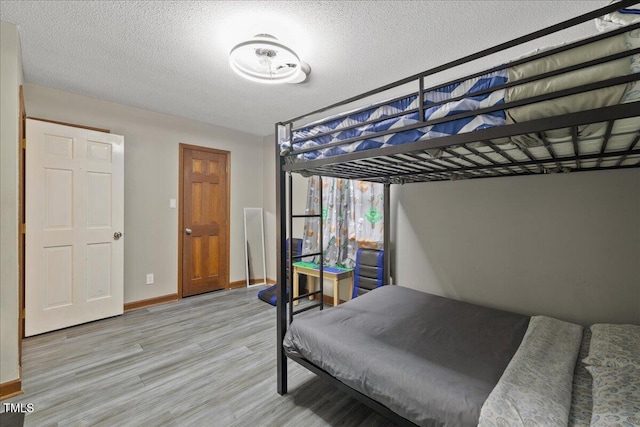 9801 Honeycutt Rd, Raleigh, NC 27614 - bedroom with wood finished floors, baseboards, and a textured ceiling