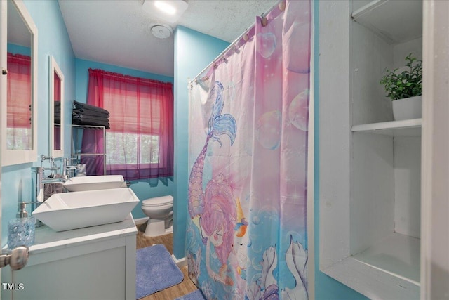 9801 Honeycutt Rd, Raleigh, NC 27614 - full bath featuring wood finished floors, double vanity, toilet, and a shower with curtain
