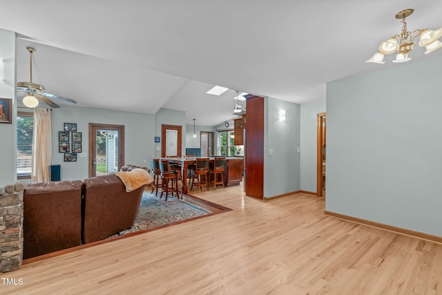 502 Hillcrest Rd, Apex, NC 27502 - living room featuring wood finished floors, lofted ceiling, ceiling fan, a chandelier, and a skylight
