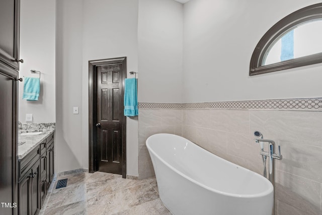 502 Hillcrest Rd, Apex, NC 27502 - full bath featuring a freestanding tub, double vanity, tile walls, and a wainscoted wall
