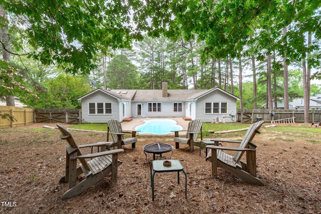 502 Hillcrest Rd, Apex, NC 27502 - rear view of house featuring a fire pit, a chimney, a fenced backyard, a gate, and view of wooded area