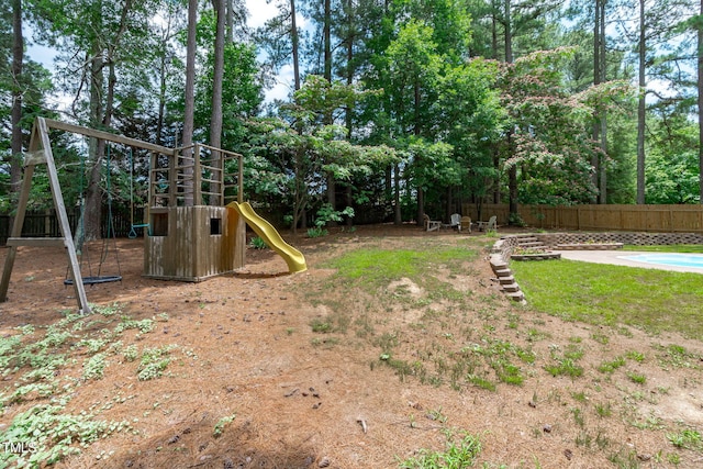 502 Hillcrest Rd, Apex, NC 27502 - fenced backyard featuring a playground and view of wooded area