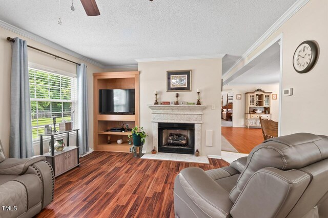4403 Jeffries Rd, Durham, NC 27704 - living area featuring crown molding, dark wood-style flooring, ceiling fan, a fireplace with flush hearth, and a textured ceiling