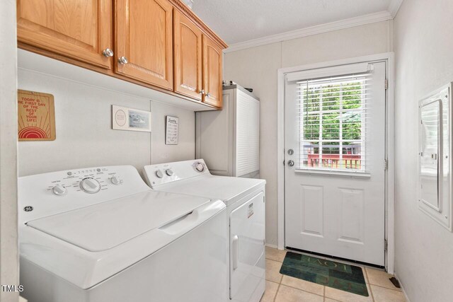 4403 Jeffries Rd, Durham, NC 27704 - laundry area with washing machine and dryer, cabinet space, light tile patterned floors, and ornamental molding