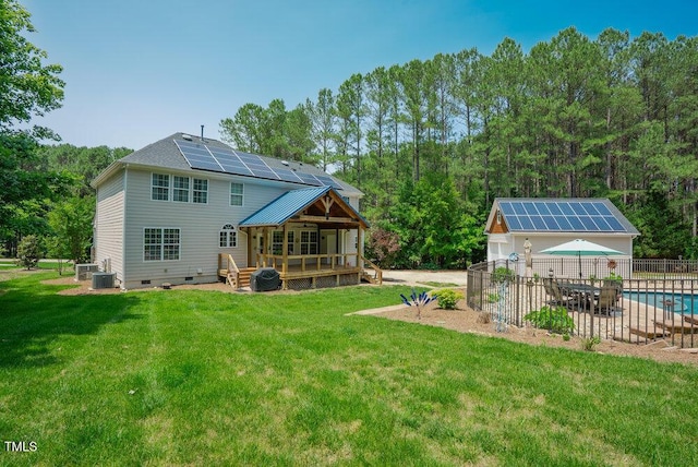 1005 Hidden River Ct, Raleigh, NC 27614 - back of property with solar panels, crawl space, a wooden deck, central air condition unit, and an outbuilding