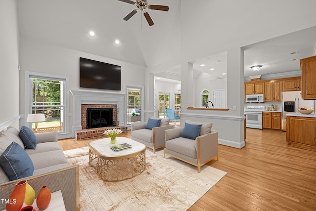 5108 Briton Pl, Fuquay Varina, NC 27526 - living room featuring ceiling fan, light wood-type flooring, a fireplace, recessed lighting, and a towering ceiling