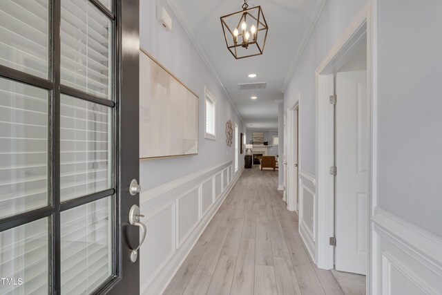 3020 High Plains Dr, Fuquay Varina, NC 27526 - hallway with crown molding, a decorative wall, a chandelier, a wainscoted wall, and light wood finished floors