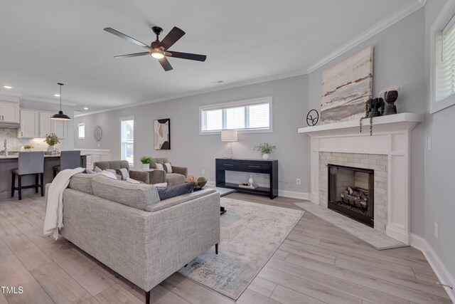 3020 High Plains Dr, Fuquay Varina, NC 27526 - living area featuring ornamental molding, light wood-style floors, a ceiling fan, a fireplace, and recessed lighting
