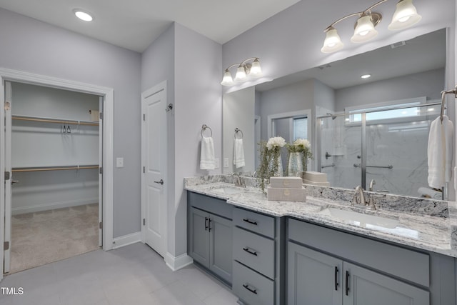 3020 High Plains Dr, Fuquay Varina, NC 27526 - bathroom with a marble finish shower, double vanity, a spacious closet, and baseboards