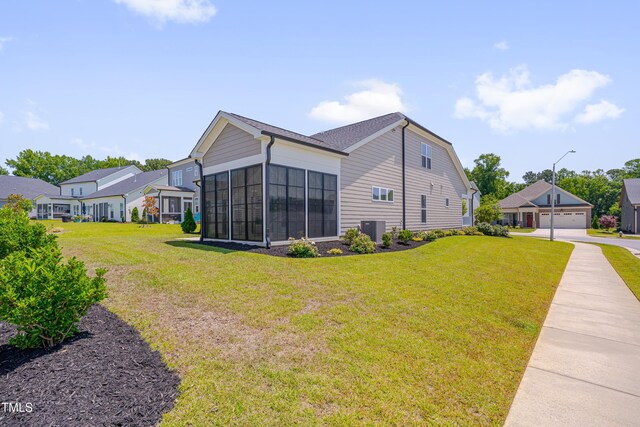 3020 High Plains Dr, Fuquay Varina, NC 27526 - view of home's exterior with a sunroom, a lawn, central AC, and a detached garage