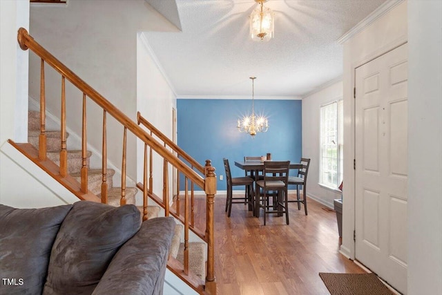 4108 Lazyriver Ln, Durham, NC 27712 - dining area with crown molding, wood finished floors, a chandelier, stairs, and baseboards