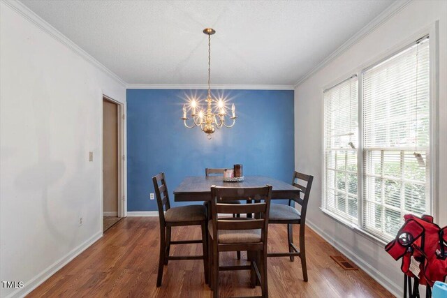 4108 Lazyriver Ln, Durham, NC 27712 - dining room featuring a chandelier, wood finished floors, ornamental molding, and baseboards