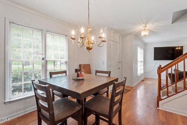4108 Lazyriver Ln, Durham, NC 27712 - dining area with a chandelier, crown molding, baseboards, light wood-style floors, and stairs